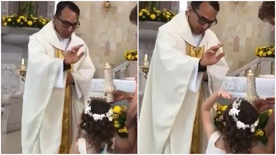 Niña choca la mano de un padre durante ceremonia religiosa